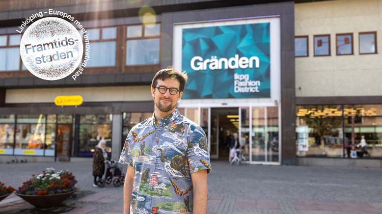 Konstnären Lorenz Sonneman står framför galleria Gränden. Han tittar in i kameran. Han bär en mönstrad skjorta och har glasögon.